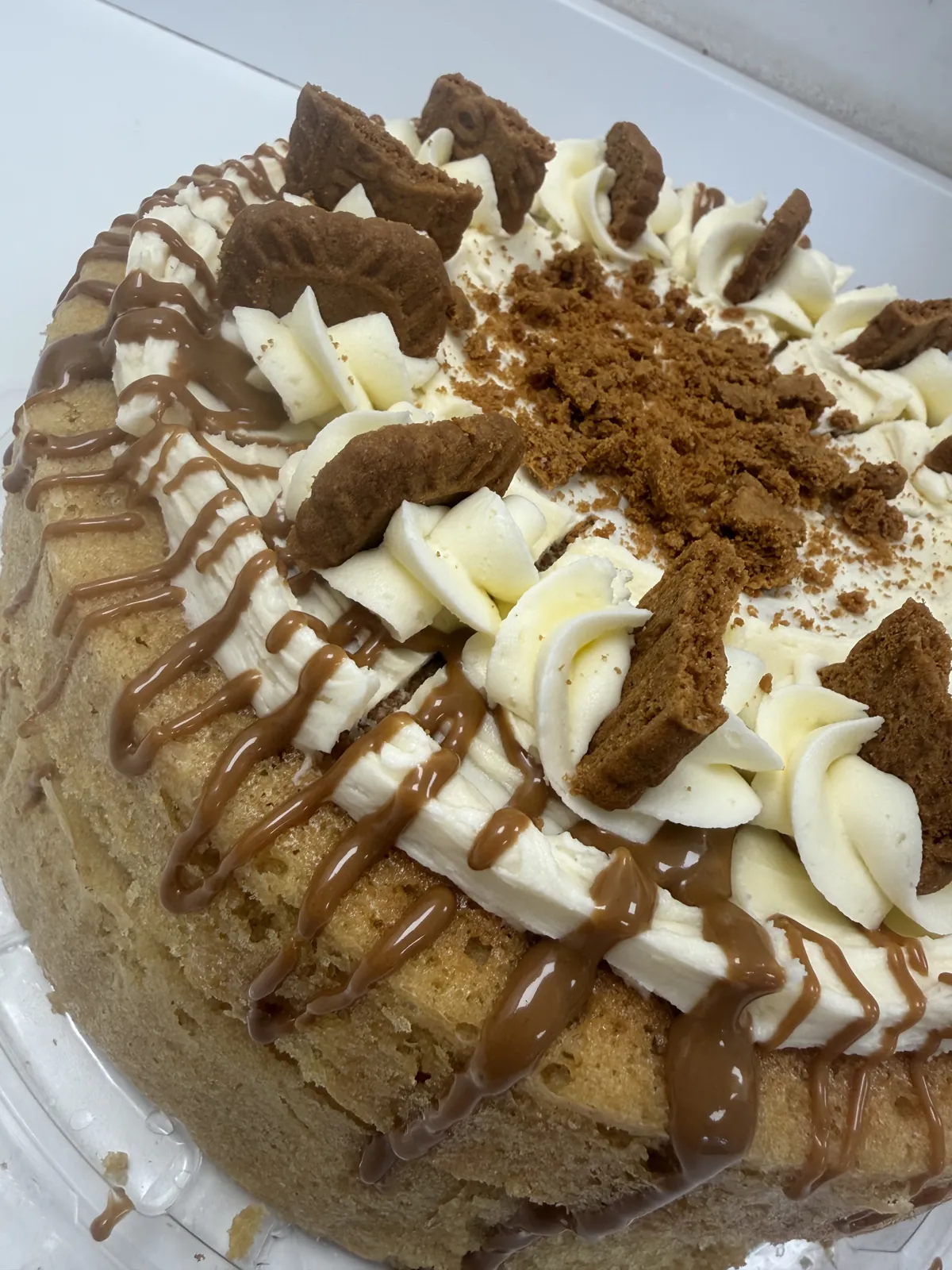Caramel biscuit cake with cream swirls, biscuit crumb and caramel drizzle